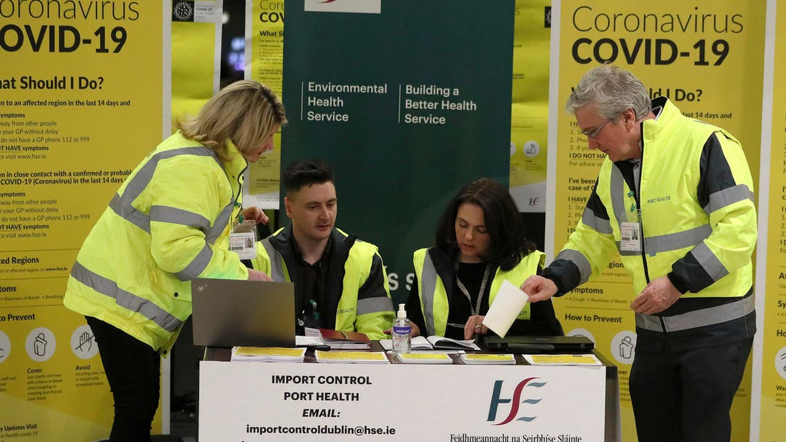 Staff conduct a public awareness campaign for COVID-19 in the baggage hall of Terminal 2 at Dublin Airport in Dublin on Feb. 28, 2020. (AP)