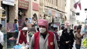 A man wears a protective face mask, following the outbreak of coronavirus, as he pushes a cart in Souq Waqif in Doha, Qatar, March 12, 2020. (Reuters)