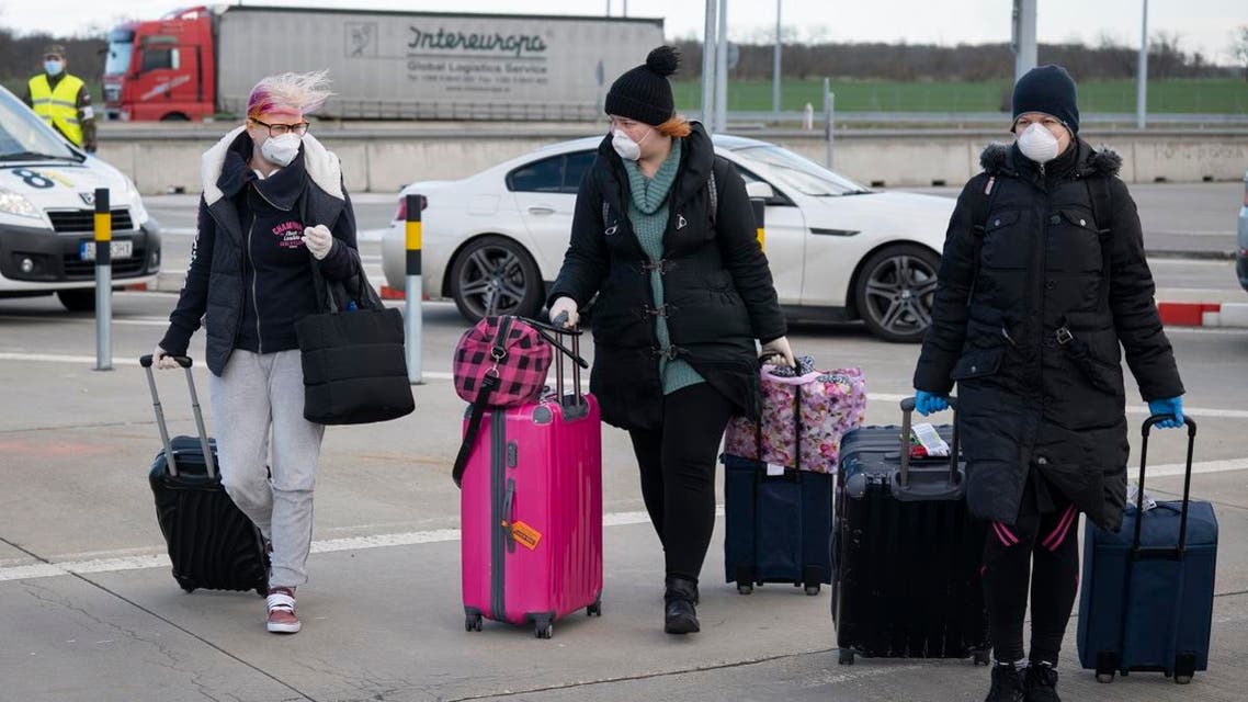 Women wearing a protective facemask due to the coronavirus COVID-19 cross the Bratislava-Jarovce border crossing between Austria and Slovakia. (AFP)