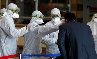 Iraqi medical staff check passengers' temperature, amid coronavirus outbreak, upon their arrival from Iran, at Najaf airport, Iraq March 5, 2020. (Reuters)