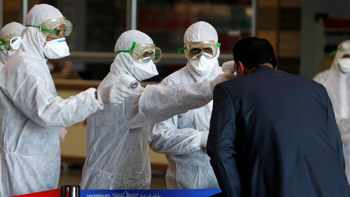 Iraqi medical staff check passengers' temperature, amid coronavirus outbreak, upon their arrival from Iran, at Najaf airport, Iraq March 5, 2020. (Reuters)