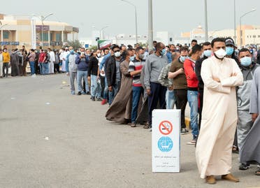 Expatriates wait in line to be tested at a makeshift center, following the outbreak of coronavirus, in Mishref, Kuwait March 14, 2020. (Reuters)