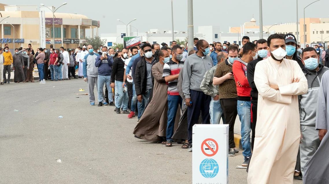 Expatriates wait in line to be tested at a makeshift center, following the outbreak of coronavirus, in Mishref, Kuwait March 14, 2020. (Reuters)