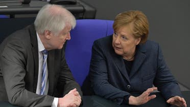 German Interior Minister Horst Seehofer chats with Chancellor Angela Merkel during a session of the German lower house of parliament Bundestag in Berlin on March 4, 2020. (AFP)