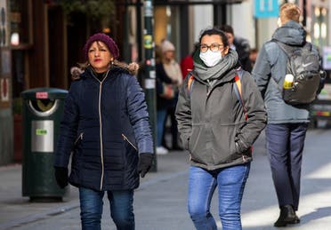 A woman wears a surgical mask while shopping in the Grafton shopping area of in Dublin on March 12, 2020. (AP)