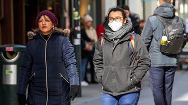 A woman wears a surgical mask while shopping in the Grafton shopping area of in Dublin on March 12, 2020. (AP)