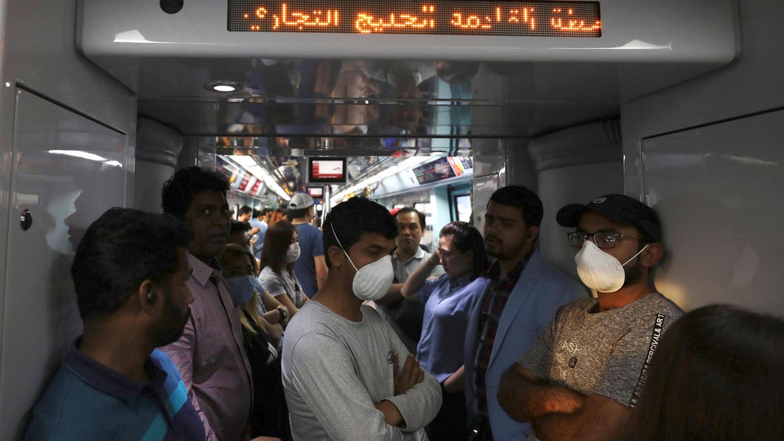 Commuters wear protective masks, following the outbreak of the coronavirus, on the metro in Dubai, United Arab Emirates, March 12, 2020. (Reuters)