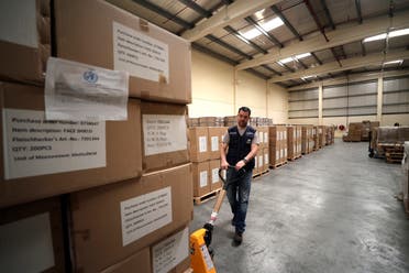A worker pulls a cart of coronavirus aid items being prepared for shipment, at a World Health Organization, WHO, facility, part of the International Humanitarian City, in Dubai, United Arab Emirates. (AP) 