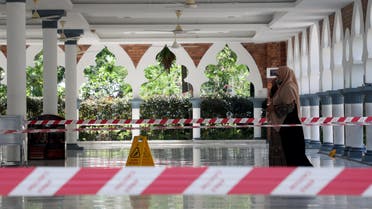 A woman wearing a protective mask walks at a mosque following the outbreak of coronavirus, in Kuala Lumpur, Malaysia March 16, 2020 (AFP)