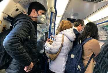 A traveler wears a mask on a busy tube in London on March 16, 2020. (AP)