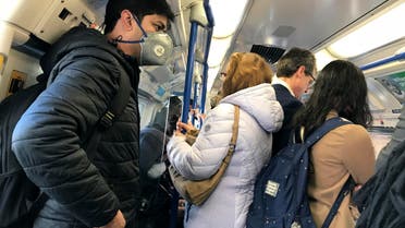 A traveler wears a mask on a busy tube in London on March 16, 2020. (AP)