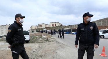 Police officers secure the area as pilgrims arrive from the airport to be quarantined in university dormitories outside Ankara on March 15, 2020. (AP)