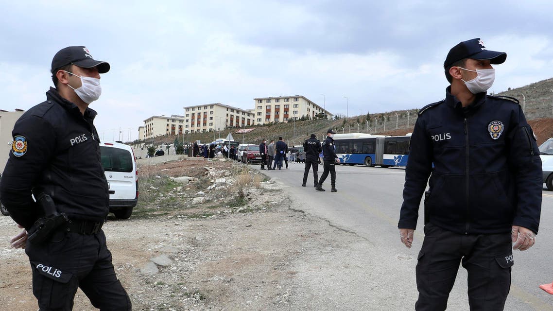 Police officers secure the area as pilgrims arrive from the airport to be quarantined in university dormitories outside Ankara on March 15, 2020. (AP)