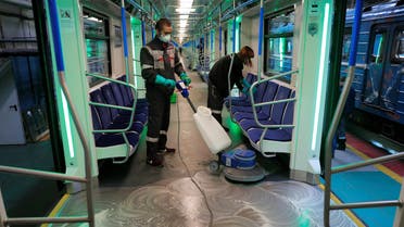 Employees wearing protective face masks clean and disinfect a subway train, as part of measures to prevent the spread of coronavirus (COVID-19) in Moscow, Russia, on March 16, 2020. (Reuters)