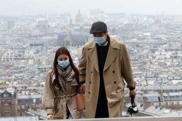 People wearing protective face masks walk in the gardens of the Montmartre's Sacre Coeur Basilica in Paris as shops, schools remain closed and workers asked to work from home if possible, part of the French government’s measures against the coronavirus outbreak, France, March 16, 2020. (Reuters)