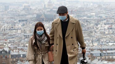 People wearing protective face masks walk in the gardens of the Montmartre's Sacre Coeur Basilica in Paris as shops, schools remain closed and workers asked to work from home if possible, part of the French government’s measures against the coronavirus outbreak, France, March 16, 2020. (Reuters)