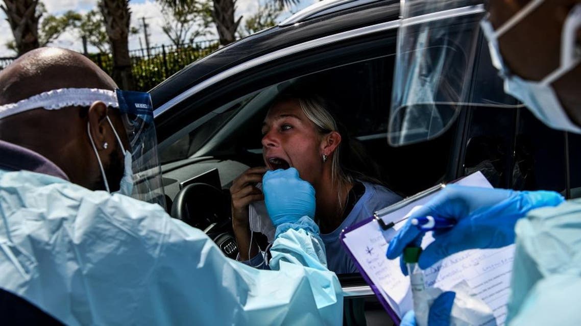 A medical personnel member takes samples of Lee Dinzik (29) at a “drive-thru” coronavirus testing lab. AFP