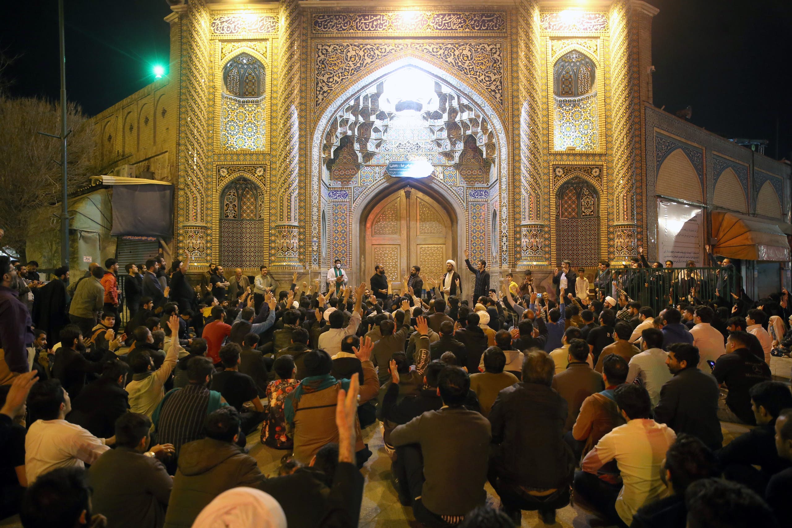 People gather outside the closed doors of the Fatima Masumeh shrine in Iran's holy city of Qom on March 16, 2020. (File photo: AFP)