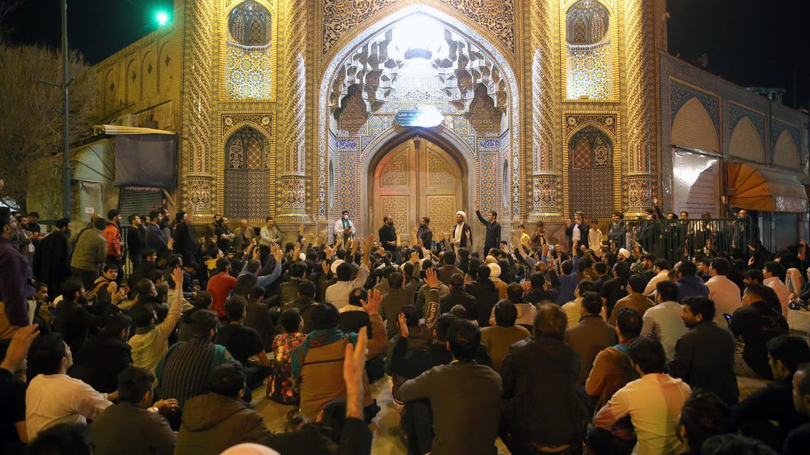 People gather outside the closed doors of the Fatima Masumeh shrine in Iran's holy city of Qom on March 16, 2020. (AFP)
