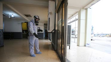 A worker wearing a protective suit disinfects a bus station, following the outbreak of coronavirus disease (COVID-19), in Algiers, Algeria March 16, 2020. REUTERS/Ramzi Boudina