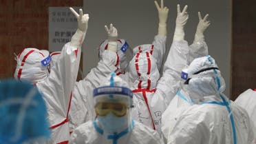 Medical staff cheer themselves up before going into an ICU ward for COVID-19 coronavirus patients at the Red Cross Hospital in Wuhan in China's central Hubei province on March 16, 2020. China reported 12 more imported cases of the novel coronavirus on March 16 as the capital tightened quarantine measures for international arrivals to prevent a new wave of infections.