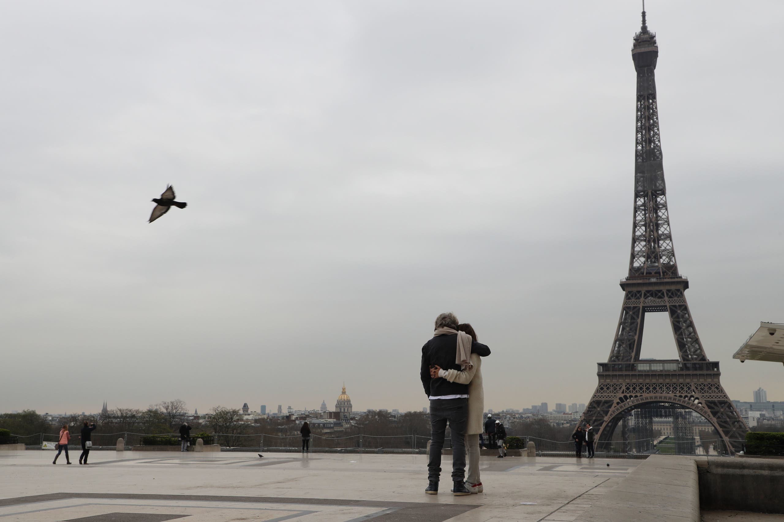 يقفان أمام برج إيفيل قبل ساعات من إعلان اغلاق البلاد (فرانس برس)
