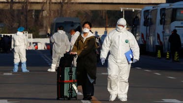Staff in protective suits accompany passengers outside a centralized facility for screening and registration near the Beijing Capital International Airport in Beijing as the country is hit by an outbreak of the novel coronavirus, China, March 17, 2020. REUTERS