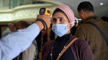 A woman wearing a protective health mask has her body temperature measured at on a touristic river boat in Egypt's southern city of Luxor on March 8, 2020. (AFP)