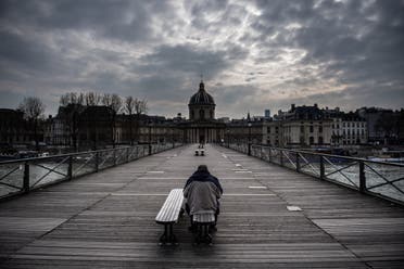 A man waits on a bench of the Pont Des Arts in Paris, France, on March 17, 2020 as a strict lockdown comes into in effect to stop the spreading of the COVID-19 in the country. (AFP)
