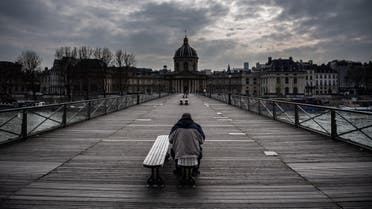 A man waits on a bench of the Pont Des Arts in Paris, France, on March 17, 2020 as a strict lockdown comes into in effect to stop the spreading of the COVID-19 in the country. (AFP)