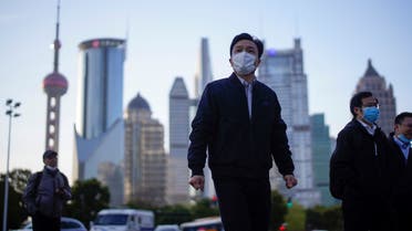 People wear protective face masks, following an outbreak of the novel coronavirus disease (COVID-19), at Lujiazui financial district in Shanghai, China, March 19, 2020. (Reuters)