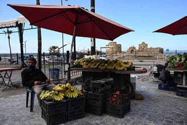 A fruit vendor waits for customers at his stall in front of Sidon’s sea castle during a nationwide lockdown implemented to slow the spread of coronavirus. (Finbar Anderson)