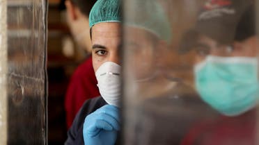 Palestinians, wearing masks as a preventive measure against the coronavirus disease, work in a bakery in Gaza City March 22, 2020. REUTERS/Mohammed Salem