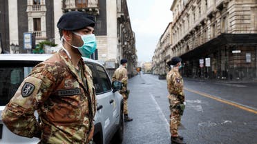 Italian soldiers wearing protective masks work at a roadblock after Italy reinforced the lockdown measures to combat the coronavirus disease in Catania, Italy, March 21, 2020. (Reuters)