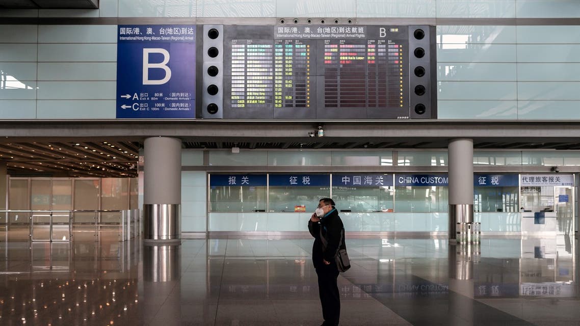 A man wearing a face mask as a preventive measure against the COVID-19 coronavirus stands at a nearly empty arrivals hall at Beijing Capital Airport in Beijing on March 16, 2020. China tightened quarantine measures for international arrivals as the country worries about a rise in imported cases of the deadly coronavirus and anger rages online at how Europe and the United States are handling the pandemic.