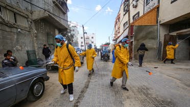 Palestinian volunteers wearing protective clothes and masks disinfect a street as a preventive measure against the spread of the novel coronavirus, in Rafah in the southern Gaza Strip, on March 22, 2020. Authorities in Gaza today confirmed the first two cases of novel coronavirus, identifying them as Palestinians who had travelled to Pakistan and were being held in quarantine since their return.