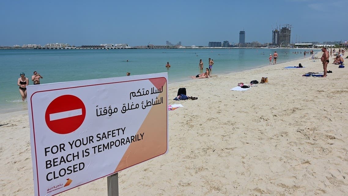 People take a sunbath along the Jumeirah Beach residence in Dubai on March 22, 2020 following its closure by authorities amid the COVID-19 coronavirus pandemic. (Reuters)