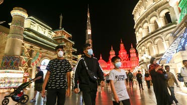 People wear protective masks, following an outbreak of coronavirus, as they walk at Global Village in Dubai. (Reuters)