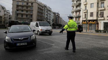 A police officer stops cars to perform checks on drivers' documents verifying purpose of movement, after the Greek government imposed a nationwide lockdown to contain the spread of the coronavirus disease (COVID-19), in Athens, Greece, March 23, 2020. REUTERS/Costas Baltas