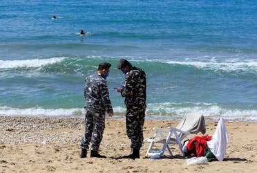Lebanese officials issue fines at the beach in Sidon amid the nation-wide lockdown, March 22. (Reuters)
