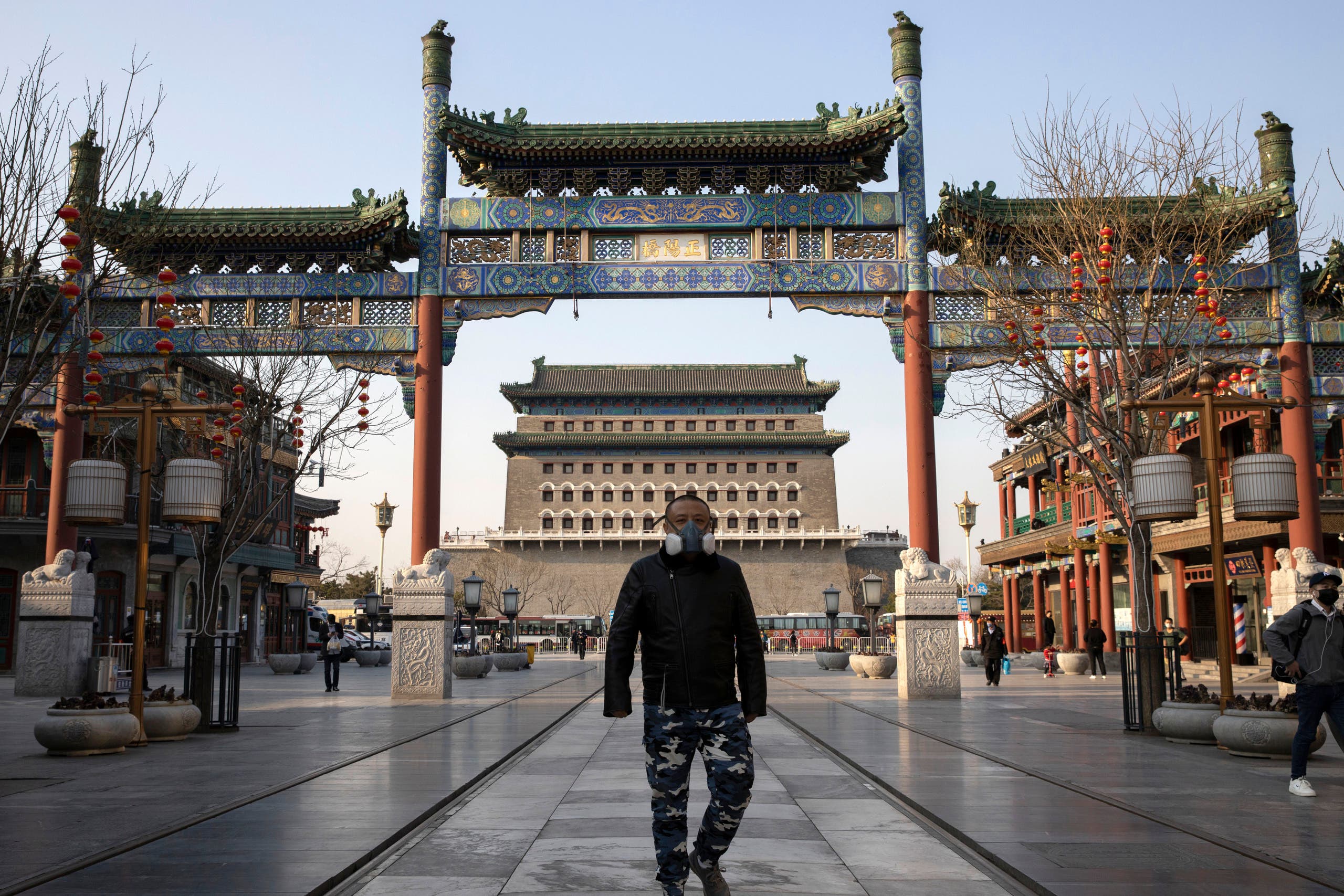A man wearing a face mask walks through a quiet retail district in Beijing on on March 23, 2020. (AP)