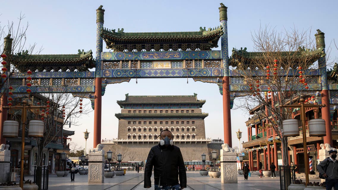 A man wearing a face mask walks through a quiet retail district in Beijing on on March 23, 2020. (AP)