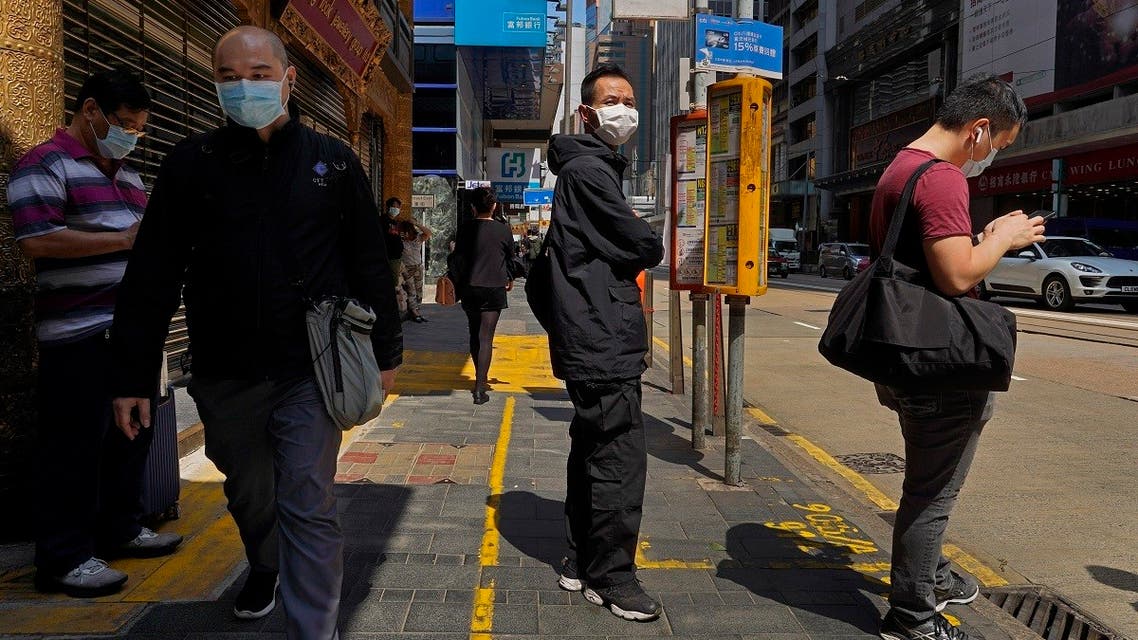 People wearing face masks walk at a down town street in Hong Kong Monday, March 23, 2020. (AP)