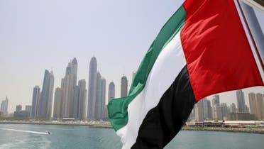UAE flag flies over a boat at Dubai Marina