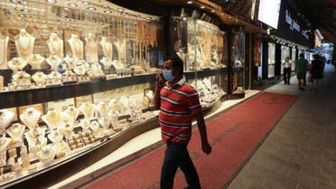 رجل يضع قناعاً واقياً في سوق الذهب في دبي في صورة بتاريخ 18 مارس