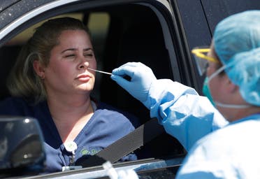 Nurse Jany Guedes, right, takes a sample for testing at a drive-through testing site for COVID-19 on March 20, 2020 in Miami. (AP)