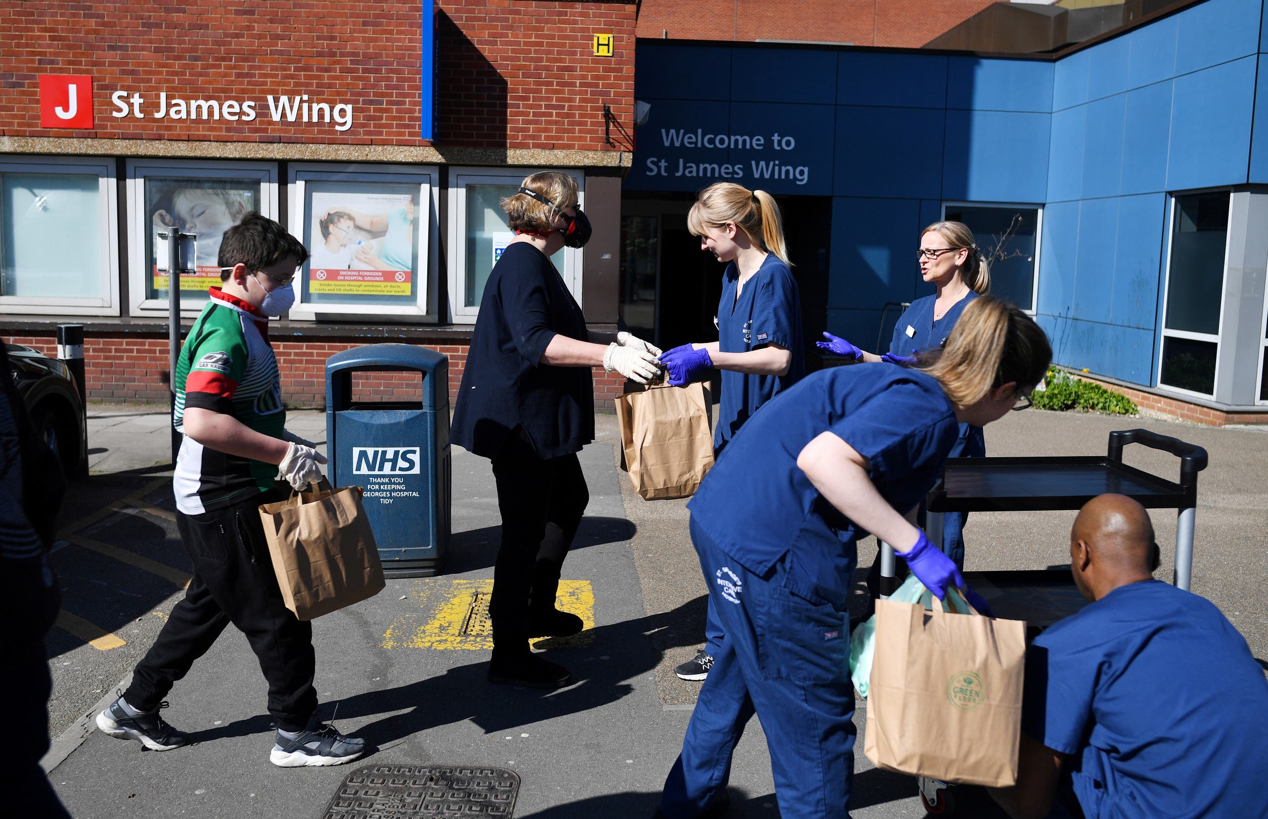 متطوعون يوصلون وجبات طعام إلى الممارسين الصحيين في أحد مستشفيات لندن