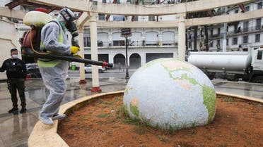 A worker wearing a protective suit disinfects a globe-shaped public garden, following the outbreak of coronavirus disease (COVID-19), in Algiers, Algeria March 23, 2020. REUTERS / Ramzi Boudina