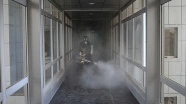 A member of firefighters wears a protective face mask, amid fear of coronavirus disease (COVID-19), as he disinfects a municipality building, ahead of the Iranian New Year Nowruz, March 20, in Tehran. (Reuters)