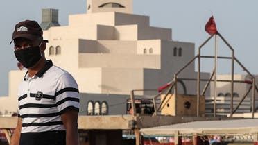 A man wearing a mask, precaution against COVID-19 coronavirus disease, walks along the Doha corniche near the Qatar Islamic Museum in the Qatari capital. (AFP)